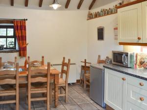 een keuken en eetkamer met een tafel en een magnetron bij Spring Cottage in Hollinsclough
