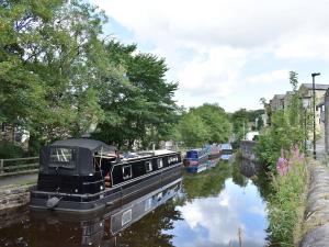 a boat is docked on the side of a canal at Whitehouse Cottage in Skipton