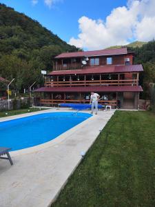 un hombre está jugando al tenis delante de una casa en Casa David en Sviniţa