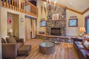 a living room with a large stone fireplace at Aspencliffe Home: Perfect Mountain Getaway w/ Hot Tub in Blue River