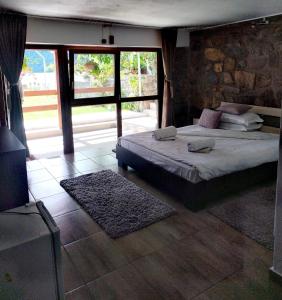 a bedroom with a bed and a stone wall at Casa David in Sviniţa