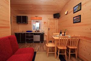 uma cozinha e sala de jantar com uma mesa e um sofá vermelho em Holiday home in Ustronie Morskie not far from the sea em Ustronie Morskie