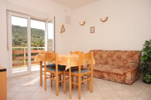 a dining room with a table and chairs and a couch at Apartments with parking space Bozava, Dugi otok - 8123 in Božava