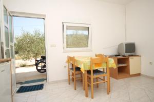 a dining room with a table and a television at Apartment Bozava 8123a in Božava