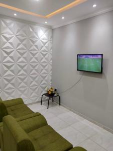 een woonkamer met 2 banken en een flatscreen-tv bij Casa Vitória in Camocim