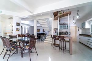 - une cuisine et une salle à manger avec une table et des chaises dans l'établissement Casa de Praia em Bombinhas Beach House, à Bombinhas
