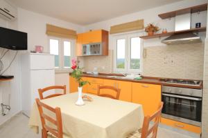a kitchen with a table with a vase on it at Apartments with a parking space Trget, Rasa - 7687 in Trget