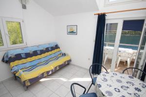 Un dormitorio con una cama y una mesa y sillas. en Apartments by the sea Pasadur, Lastovo - 8386, en Lastovo