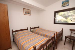 twee bedden in een kamer met een raam bij Secluded fisherman's cottage Lavdara, Dugi otok - 8155 in Sali