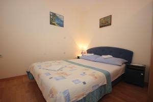 a bedroom with a bed with a blue head board at Apartments with a parking space Vis - 8869 in Vis