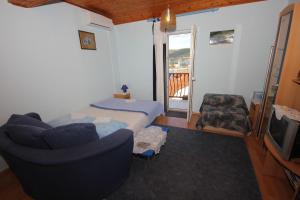a room with a bed and a couch and a tv at Apartments with a parking space Vis - 8869 in Vis