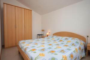 ein Schlafzimmer mit einem Bett mit einer bunten Decke in der Unterkunft Apartments by the sea Nerezine, Losinj - 3479 in Nerezine