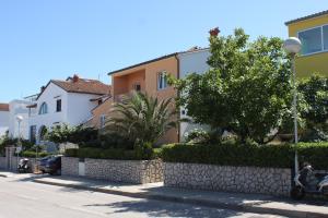 uma fila de casas ao lado de uma rua em Apartments with a parking space Mali Losinj (Losinj) - 7964 em Mali Lošinj