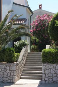 um conjunto de escadas que levam a uma casa com flores em Apartments with a parking space Mali Losinj (Losinj) - 7964 em Mali Lošinj