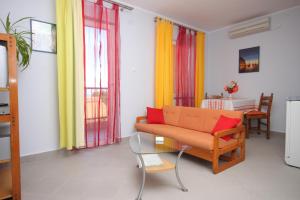 uma sala de estar com um sofá e uma mesa em Apartments with a parking space Mali Losinj (Losinj) - 7964 em Mali Lošinj