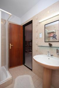 uma casa de banho com um lavatório, uma banheira e um chuveiro em Apartments with a parking space Mali Losinj (Losinj) - 7964 em Mali Lošinj