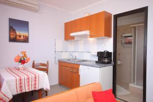 uma pequena cozinha com mesa e bancada em Apartments with a parking space Mali Losinj (Losinj) - 7964 em Mali Lošinj