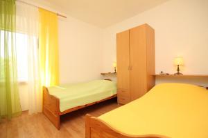 a small bedroom with two beds and a cabinet at Apartments with a parking space Sali, Dugi otok - 8084 in Sali