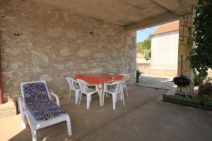 een patio met een tafel en stoelen en een grill bij Apartments with a parking space Sali, Dugi otok - 8084 in Sali