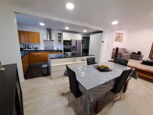 Friendly house في فونشال: مطبخ وغرفة معيشة مع طاولة وكراسي