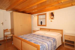 ein Schlafzimmer mit einem Bett und ein Mädchen im Spiegel in der Unterkunft Seaside holiday house Miholascica, Cres - 8073 in Martinšćica