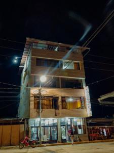 un edificio por la noche con una moto aparcada delante en Yacumama Santa Teresa, en Santa Teresa