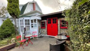 a red door on a house with chairs and a table at Enchanted Escape in Picton