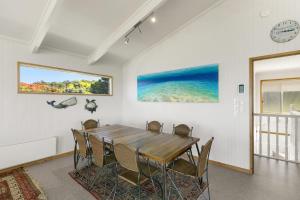 ローンにあるBoston Beach House - BYO Linenの木製のテーブルと椅子のあるダイニングルーム
