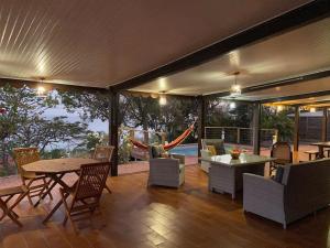 a patio with a table and chairs and a hammock at Le Caillou *** Belle villa, 4 chambres, piscine, vue mer *** in Le Diamant +25 photos