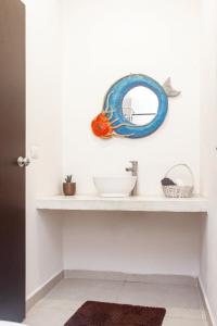 un estante con un espejo en una pared blanca en Buena onda residence en Tulum