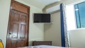 1 dormitorio con puerta y TV en la pared en Chillinn at duke en Kingston