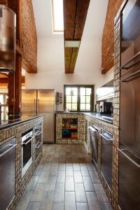 uma grande cozinha com electrodomésticos de aço inoxidável e paredes de tijolos em Holiday, party and relax vila 