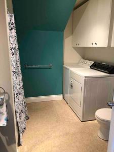 a small kitchen with a toilet and a green wall at Aux quatre vents 4,5 grand logement privé in Lac-Mégantic
