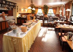 een lange tafel met eten erop in een restaurant bij Hotel Grasbrunner Hof in Grasbrunn