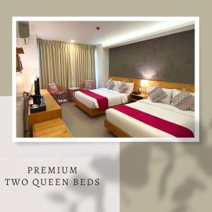 two beds in a hotel room with two queen beds at Bay's Inn Resort in Baler