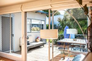 a room with a screened in porch with a table and a table at Le Shack - Freycinet Holiday Houses in Coles Bay