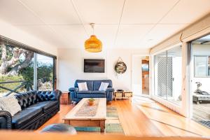 a living room with a couch and a table at Le Shack - Freycinet Holiday Houses in Coles Bay