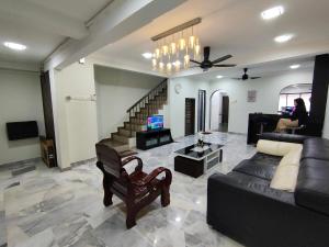uma sala de estar com um sofá e uma mesa em Three-Bedroom House at Tyara Homestay Sunway em Petaling Jaya