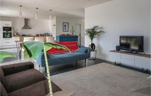 sala de estar con sofá azul y TV en Amazing Home In Saint-gnies-de-fonted With Private Swimming Pool, Can Be Inside Or Outside, en Saint-Geniès-de-Fontedit