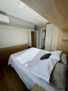 a bedroom with a large bed with white sheets at Apartamento completo para veraneio in Torres