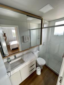 a bathroom with a sink and a toilet and a shower at Apartamento completo para veraneio in Torres