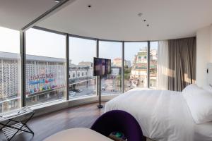 Cette chambre comprend un grand lit et une grande fenêtre. dans l'établissement SOJO Hotel Ga Hanoi, à Hanoï