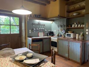 a kitchen with a table and a kitchen with a stove at Gîte Sauvagny, 3 pièces, 4 personnes - FR-1-489-13 in Sauvagny