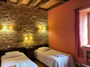 a room with two beds and a stone wall at Gîte Sauvagny, 3 pièces, 4 personnes - FR-1-489-13 in Sauvagny