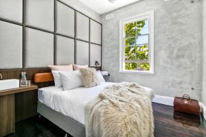 um quarto com uma cama com um cobertor de peles em Terminus Hotel Pyrmont em Sidney