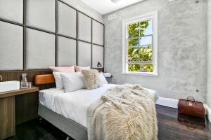 a bedroom with a bed with a fur blanket on it at Terminus Hotel Pyrmont in Sydney