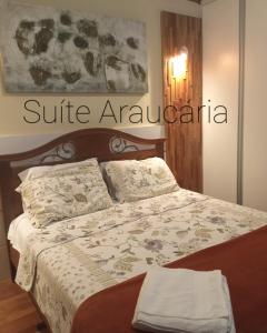 um quarto com uma cama com uma colcha em cima em Pousada Campos SONHO MEU em Campos de Jordão