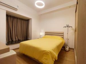 sypialnia z żółtym łóżkiem i oknem w obiekcie Mian's Creative Space w mieście Xiamen