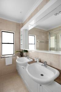 ein weißes Badezimmer mit 2 Waschbecken und einem Spiegel in der Unterkunft Belle De Jour, Penthouse 5, Noosa Heads in Noosa Heads