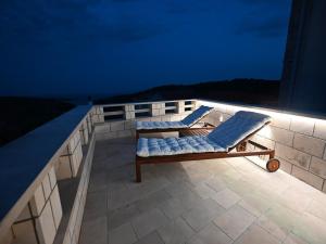 two lounge chairs on the roof of a building at night at House Palma in Selca